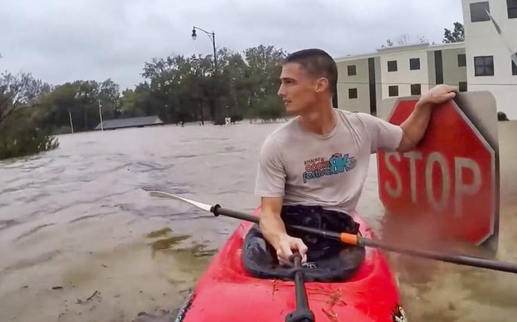 Man Kayaks Through Flooded Roads